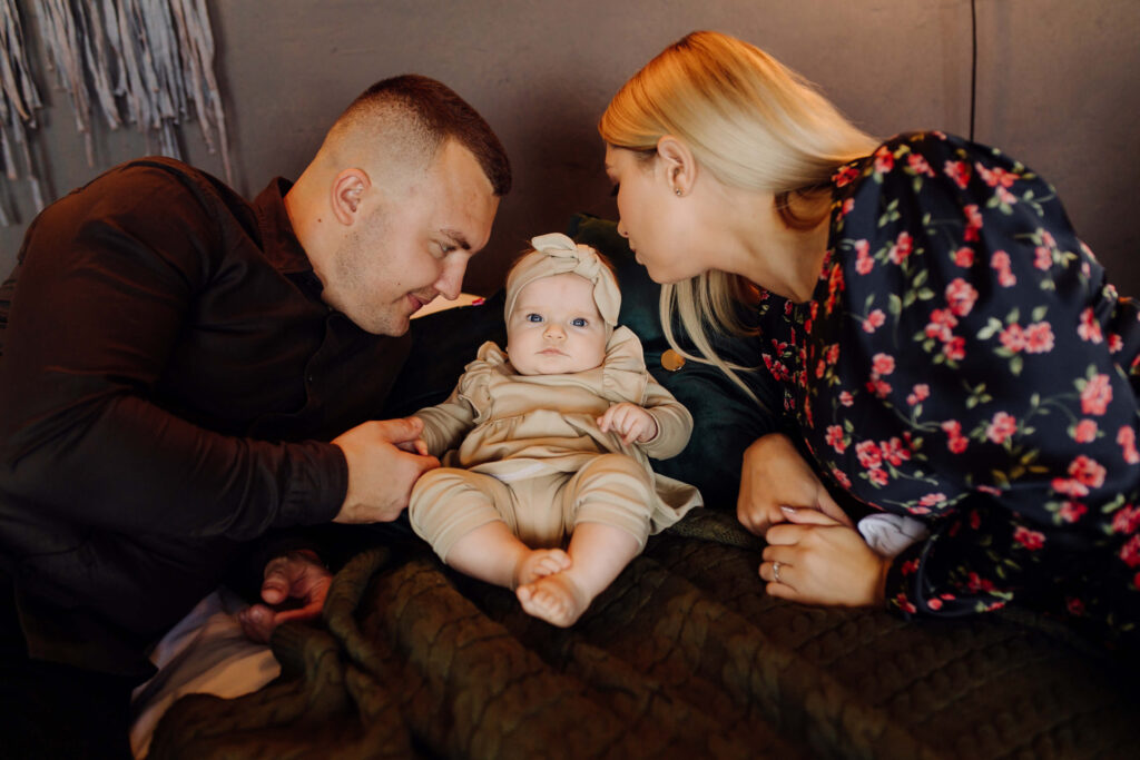 portrait young family 1 Newborn baby in parent’s arms with clock showing birth time